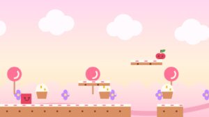 ピンクの空に綿あめ雲、ペロペロキャンディーとカップケーキが並ぶスイーツランドのゲーム画面